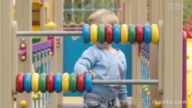 小男孩玩珠算与彩色环在两个杠上儿童游乐场，他正在学习